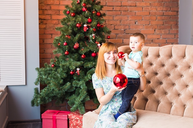 Portrait of happy mother and child holding bauble