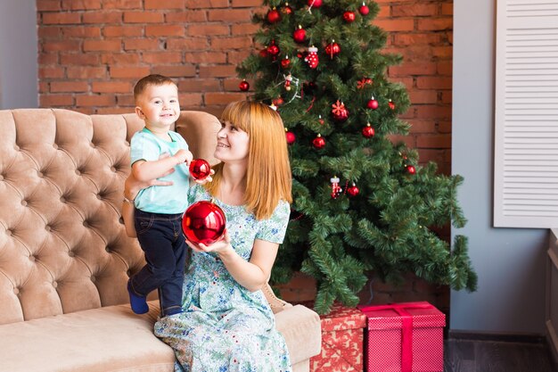 Portrait of happy mother and child holding bauble