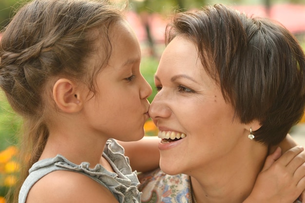 Portrait of happy mother and daughter smiling outdoors