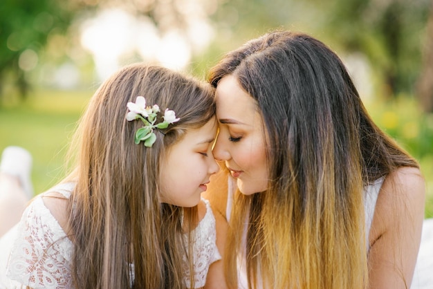 Portrait of a happy mother and daughter in the summer in the park Happy family Happy Mother's Day A postcard for Mother's Day