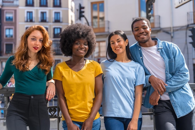 Portrait of happy multiethnic friends on city street laughing together outdoors