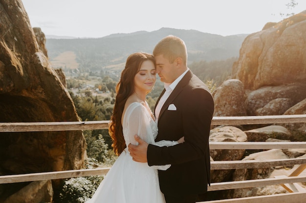 Portrait of happy newlyweds hugging, smiling and looking at each other. Concept of wedding couple