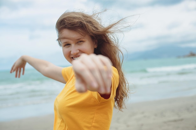 Portrait of happy positive red hair girl young beautiful carefree woman enjoying summer vacation at sea beach in exotic tropical country