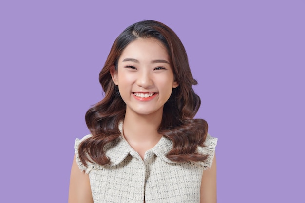 Portrait of happy and positive woman close eyes smiling carefree on purple background