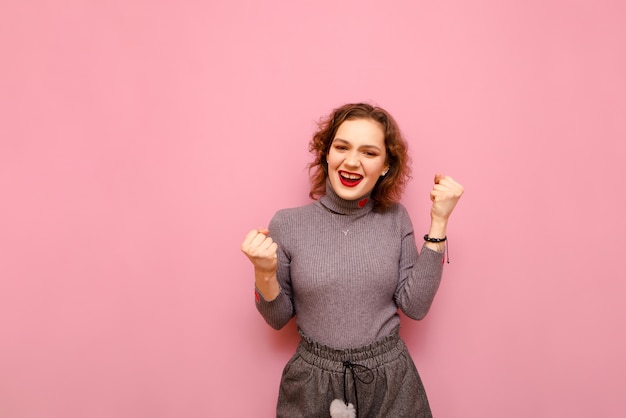 Portrait of happy pretty lady in gray sweater and curly hair