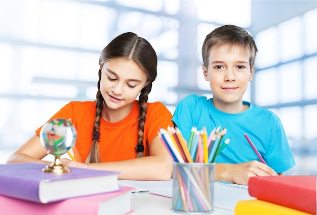 Portrait of happy school children drawing with crayons