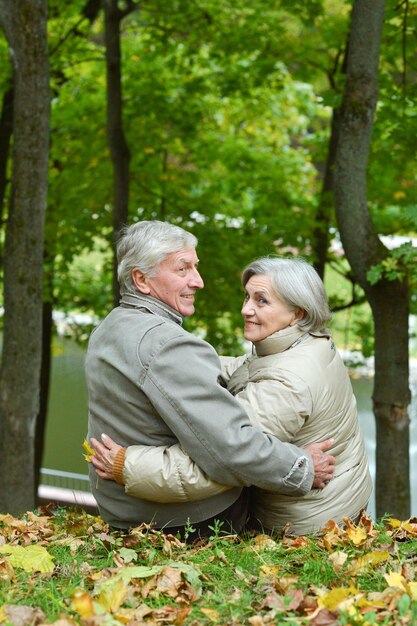 Portrait of happy senior couple hugging in park