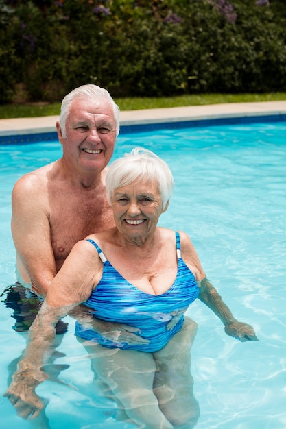 Portrait of happy senior couple in the pool on a sunny day