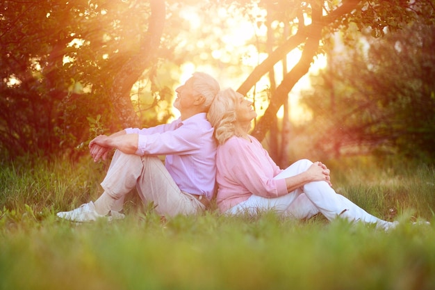 Portrait of happy senior couple resting in autumnal park