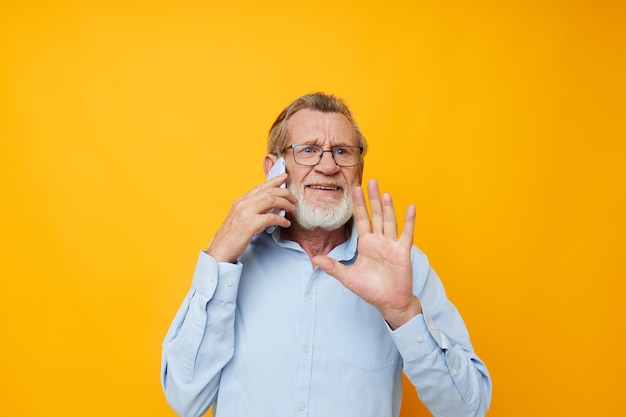 Portrait of happy senior man talking on the phone posing closeup isolated background