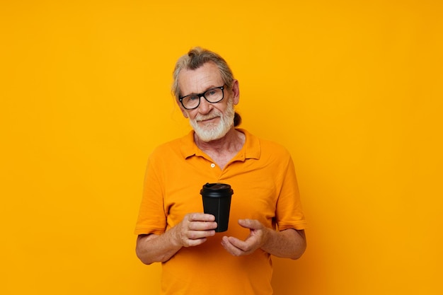 Portrait of happy senior man with black disposable cup isolated background