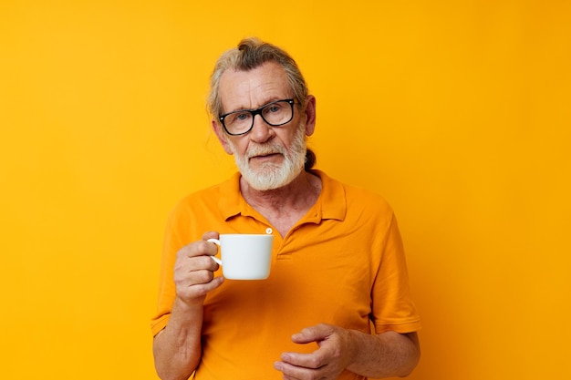 Portrait of happy senior man with a white mug of drink cropped view