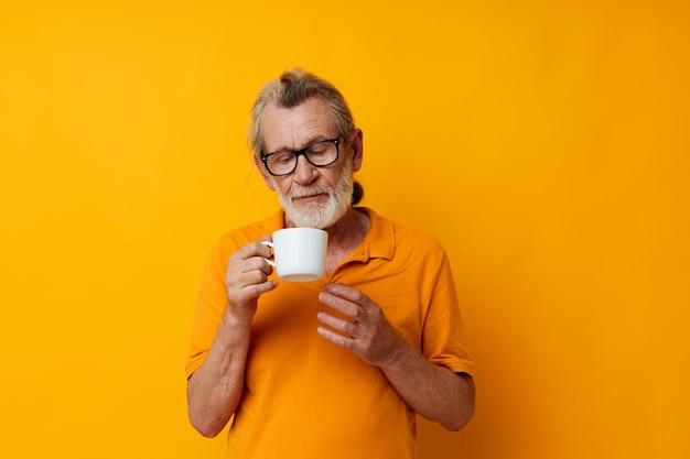 Portrait of happy senior man with a white mug of drink cropped view