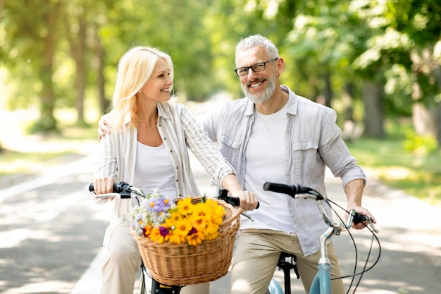 Portrait of happy senior spouses having a ride on bicycles in park