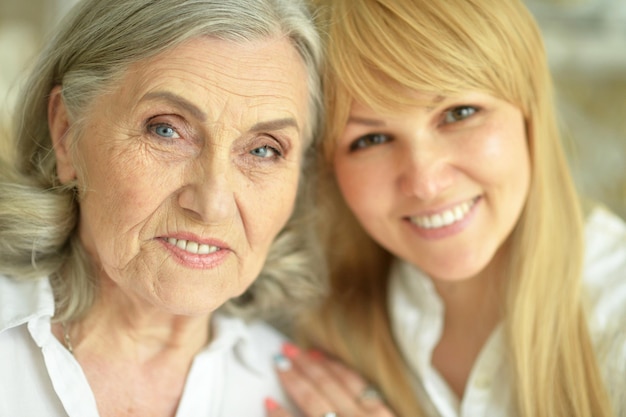 Portrait of happy Senior woman with daughter posing at home