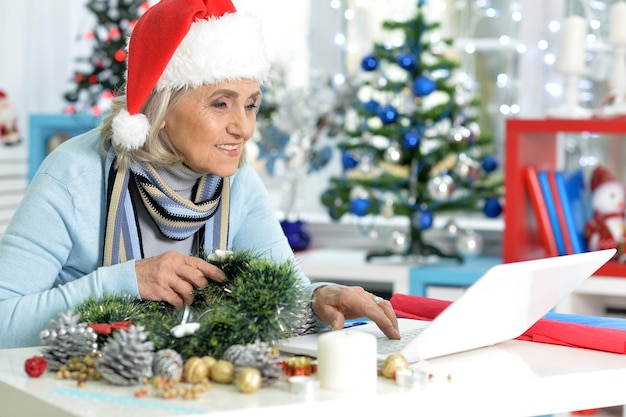 Portrait of happy senior woman with laptop