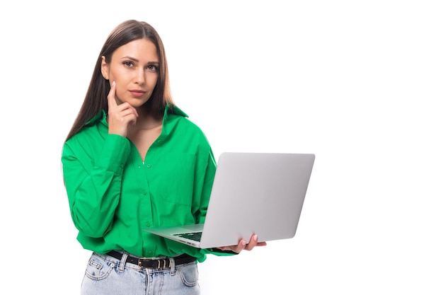 Portrait of a happy slim cute browneyed brunette woman dressed in a green shirt working using a