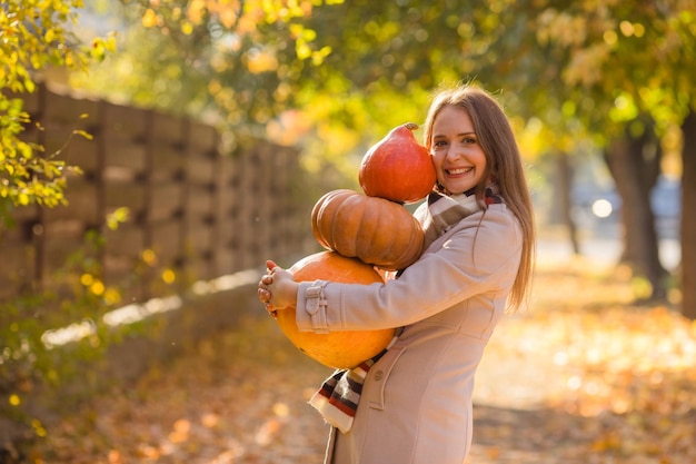 Portrait of happy smile woman with pumpkins in hand