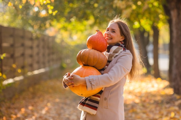 Portrait of happy smile woman with pumpkins in hand