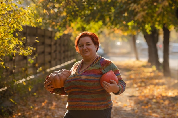 Portrait of happy smile woman with pumpkins in hand