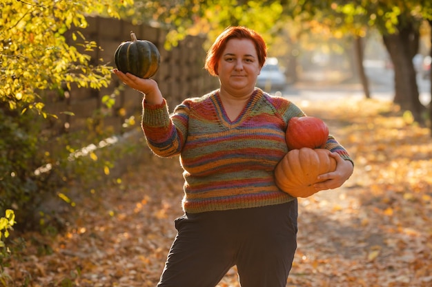 Portrait of happy smile woman with pumpkins in hand