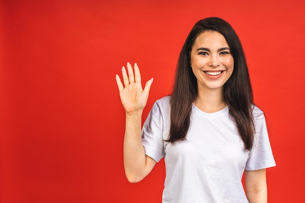 Portrait of happy smiling brunette business woman girl in casual isolated over red background