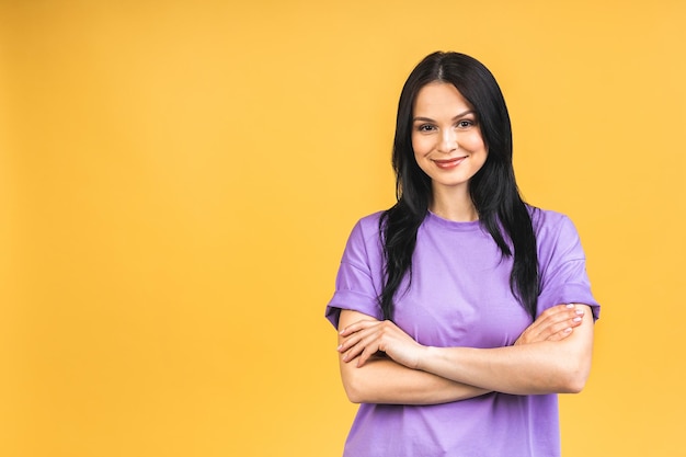 Portrait of happy smiling brunette girl in casual isolated over yellow background