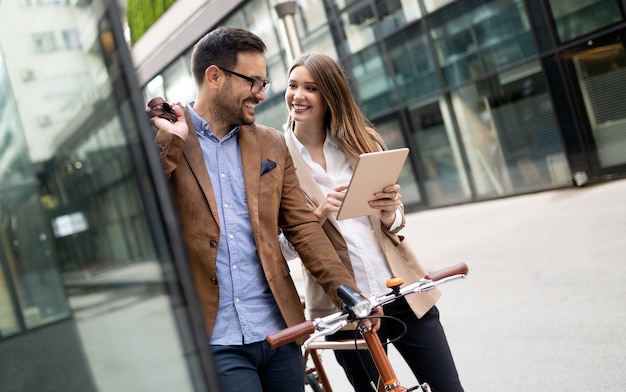 Portrait of happy smiling business people talking in the city