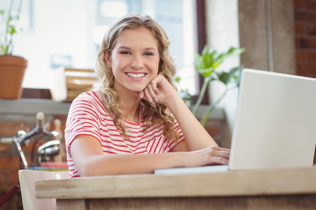 Portrait of happy smiling businesswoman with laptop in bright office