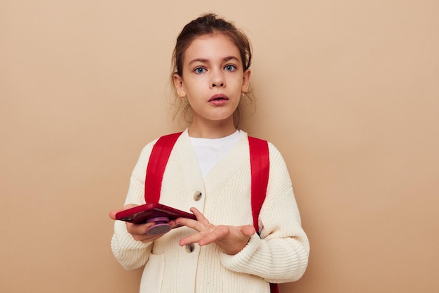 Portrait of happy smiling child girl schoolgirl backpack phone in hand childhood unaltered