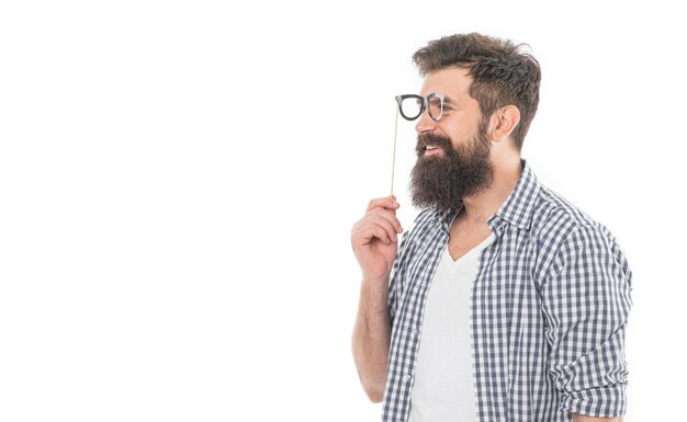 Portrait of happy smiling funny bearded man guy making fun with party glasses props photobooth in casual style studio isolated on white copy space