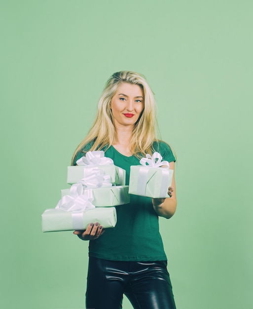 Portrait of a happy smiling girl in green holding present box