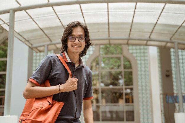 Portrait of happy and smiling student on the campus front yard