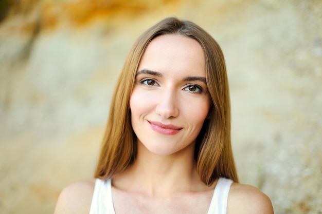 Portrait of a happy smiling woman standing and looking at the camera in a summer day