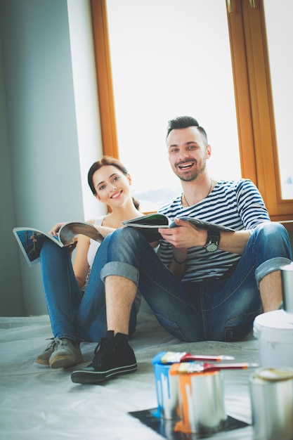 Portrait happy smiling young couple painting interior wall of new house Young couple