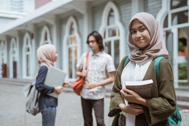 Portrait of happy students looking at the front on the campus yard