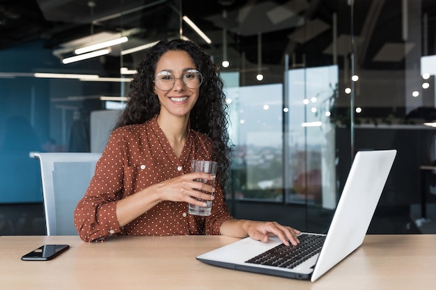 Portrait of happy and successful business woman inside modern office building female worker smiling