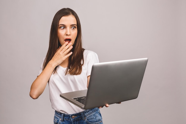 Portrait of happy surprised woman standing with laptop