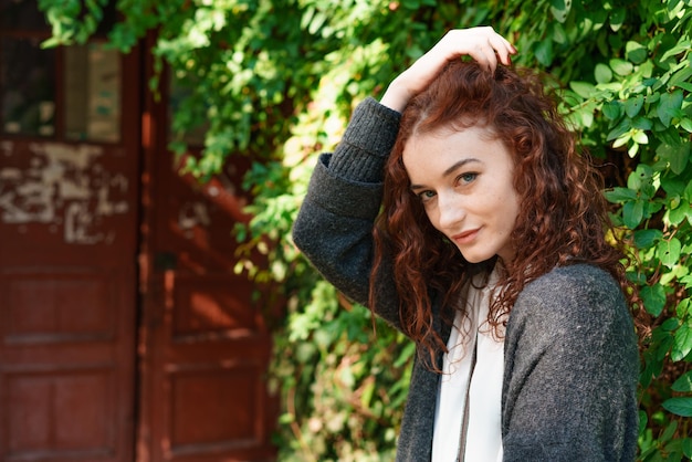 Portrait happy tender ginger girl with blue eyes and freckles looking at camera