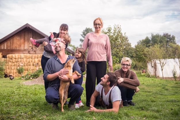 portrait of happy three generations family with dog at beautiful countryside farm