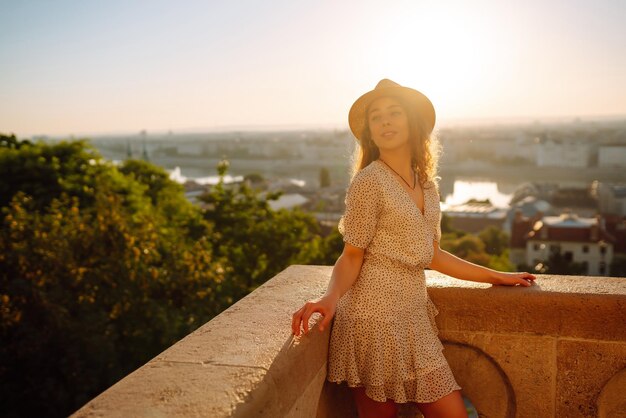 Portrait of happy tourist in hat at dawn enjoys cityscape Traveling in Europe Concept tourism