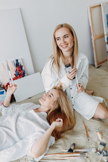 Portrait of happy twin girls artists Sister girls in a photo studio on the sand