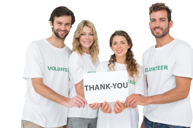 Portrait of happy volunteers holding &#039;thank you&#039; board