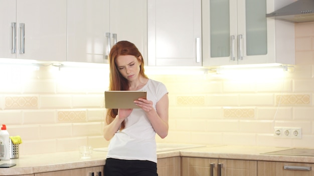 Portrait of happy woman copywriter working freelance project online sitting at home in kitchen