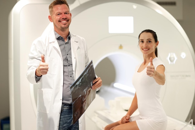 Portrait of happy woman patient showing thumbs up gesture at mri procedure magnetic resonance