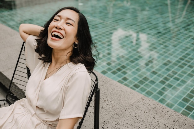 Portrait happy woman relax near swimming pool