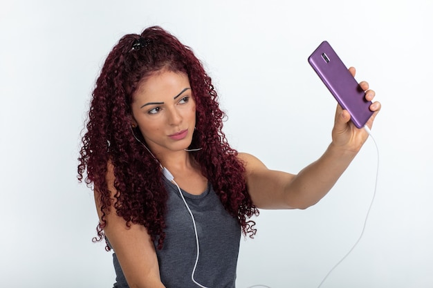 Portrait of a happy woman using cellphone and headphones