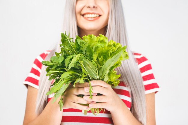 Photo portrait of happy woman with lettuce isolated over white background. food healthy concept. close-up.