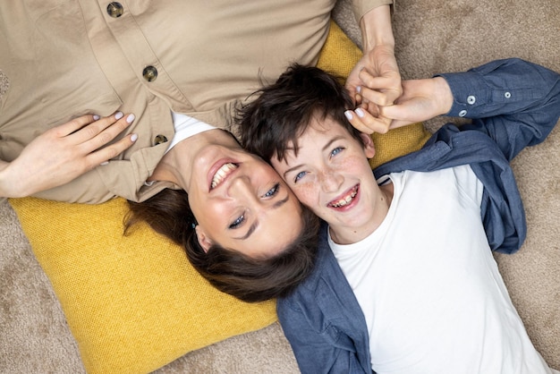 Portrait of happy woman with son mother and boyfriend smiling and looking at camera lying together