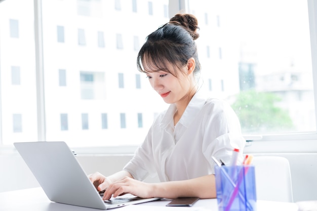 Portrait of happy and working young businesswoman